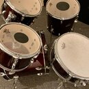 Čtyři bubny v tmavě červeném lesklém provedení s chromovaným kováním. Na blanách jsou vidět nápisy PLATINE a REMO. Povrchy blan vykazují známky použí…