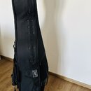 Černý polotvrdý obal na hudební nástroj z textilie. Na boční části je umístěna bílá oválná nálepka s nápisem "Behringer". Povrch obalu je v dobrém st…