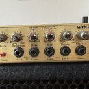 Detailní pohled na ovládací panel basového komba v béžové barvě. Na panelu jsou nápisy WTX-264, Bass Guitar Amplifier a logo EDEN. Jsou zde ovládací…