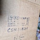 Detail hnědé kartonové krabice s několika razítky a nápisy. Je zde vidět text VLHKO T SLA, ŠKODÍVANI a výrazný nápis ČSN 368261. V dolní části jsou m…