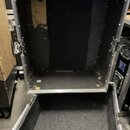 Otevřený transportní flightcase s hliníkovými hranami a černým vnitřním polstřením. Povrch vnitřní stěny vykazuje výrazné opotřebení, škrábance a sto…