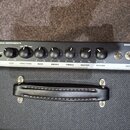 Horní ovládací panel kytarového komba v černé barvě s bílými nápisy. Na panelu jsou uvedeny názvy FENDER MUSICAL INSTRUMENTS a BASSBREAKER 15, přepín…