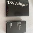 Černá krabička s bílým nápisem 18V Adapter. Vedle ní je menší černá krabička s bílým nápisem DC Cables a textem Dunlop Manufacturing, Inc. P.O. Box 6…