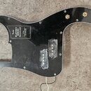 Černý plastový pickguard pro basovou kytaru s vyřezem pro snímače. Na povrchu je bílý nápis Fender PLAYER II SERIES PRECISION BASS s doplňujícími tex…