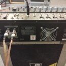 Zadní strana černého rackového mixážního pultu s integrovaným zesilovačem. Na zadním panelu jsou nápisy SPEAKER OUTPUTS, RIGHT 250W @ 4Ω X2 a LEFT 25…