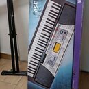 Kartonová krabice s obrázkem keyboardu. Na krabici je nápis PSR-350 a logo YAMAHA. V levé části je vidět černý kovový stojan na klávesy.