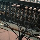 Zadní strana černého mixážního pultu s řadou vstupů a výstupů. Na levé straně je vidět nápis STUDIOLIVE a logo PreSonus. Zařízení je zapojeno do něko…