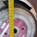 Detailní pohled na zadní stranu reproduktoru s přiloženým žlutýmv metrým. Na růžovém štítku jsou nápisy MADE IN GERMANY, type, manufactured a datum M…