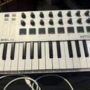 Bílá kompaktní klaviatura s černými klávesami. Na horním panelu je nápis MINILAB mkII a v dolní části značka ARTURIA s mottem TAKE YOUR EXPERIENCE YO…