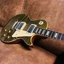 Elektrická kytara s žlutou flamed maple deskou a hnědými boky. Nástroj má dva humbuckery, bílý pickguard a čtyři zlaté ovládací knoflíky. Na hmatníku…