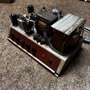 Fotografie zachycuje vnitřek elektronického zařízení, pravděpodobně zesilovače, bez krycího krytu. Na šasi jsou vidět elektronky, kondenzátory, trans…