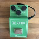 Zelený kytarový efekt pedál s nápisy TUBE SCREAMER, Overdrive Pro TS808 a značkou Ibanez. Na horní části jsou tři černé ovládací knoflíky s popisky T…