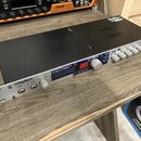 Černý rackový procesor s hliníkovým předním panelem. Na panelu jsou nápisy Digitech, GSP1101 Guitar Preamp / Processor a Output Level. Zařízení obsah…