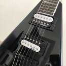 Černá elektrická kytara s hranatým tvarem těla a hnedým hmatníkem. Nástroj má dva humbuckery s bílými kryty snímačů, na kterých je napsán nápis Jacks…