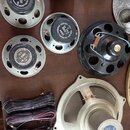 Fotografie zobrazuje několik starších reproduktorů a tři svazky elektrických kabelů na hnědé desce. Na reproduktorech jsou vidět nápisy „VEB Elektroa…