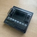 Černý plastový ochranný kryt značky DECKsaver na hudební zařízení. Na přední části je vidět bílý nápis 1010music a popisky tlačítek jako PADS, KEYS,…