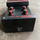 Černý kytarový efekt s červenými oválnými knoflíky. Na zařízení jsou nápisy YAMAHA, MBD-20M a MULTI DISTORTION. Povrch je mírně znečištěný prachem a…