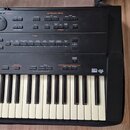 Černý digitální klavír s bílými a černými klávesami. Na horním ovládacím panelu jsou nápisy KEYBOARD MODE, TONE a GM/GS MODE, dále tlačítka s označen…