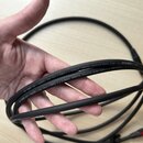 Černý instrumentální kabel smatným povrchem, který drží ruka. Na kabelu je bílý nápis: SPIRIT LLX • Highflex Low Loss • [OFC] 1 x 0,38mm² (AWG21) Adv…