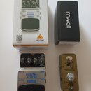 Na fotografii je efekt pedál Digital Reverb DR600 značky behringer v originální krabici a vedle něj černá krabička s nápisem Mo'vall. Pedál je stříbr…