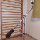 Kovový mikrofonní stojan s výsuvným ramenem a stříbrným chromovaným povrchem. Na spodní části stojanu je viditelný červený štítek s bílým nápisem "TA…