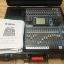 Digitální mixážní pult Yamaha 01V96 v černém transportním kufru. Vedle přístroje leží bílá uživatelská příručka s nápisy YAMAHA, 01V96 a DIGITÁLNÍ MI…