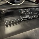 Černý rackový procesor s nápisem AXE-FX III a podtitulem PREMIER PROCESSOR MARK II. Na předním panelu je umístěn velký displej, ovládací knoflík VALU…