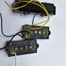 Tři černé snímače k elektrické kytáře s viditelnými cívkami a mosaznými póly. Snímače mají připojené elektrické vodiče v žluté, černé a modré barvě.…