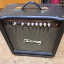 Černý akustický kombozesilovač s koženým potahem, kovovými rohy a madlem. Na předním panelu je nápis 25W ACOUSTIC AMPLIFIER TROUBADOUR a logo Ibanez.…