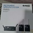 Fotografie znázorňuje krabici s bezdrátovým systémem pro nástroje značky AKG by HARMAN. Na obalu je nápis INSTRUMENT WIRELESS SYSTEM a model WMS40 MI…