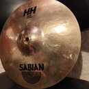 Kovový činel typu splash v přirozené zlatavé barvě s viditelným rakováním povrchu. Na činely jsou černé nápisy HH Splash 12"/30cm a SABIAN s doprovod…