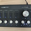 Černý audio rozhraní s nápisem AUDIOFUSE STUDIO. Zařízení obsahuje čtyři vstupní kanály označené jako INPUT CHANNEL 1 až 4, každý s knoflíkem GAIN a…