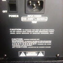 Detail zadní strany elektronického zařízení s černým povrchem. Je zde vypínač s nápisy ON a OFF, označení POWER a vstup pro napájecí kabel INPUT POWE…