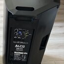 Černý aktivní reproduktor s plastovým korpusem a integrovanou úchytí. Na zadním panelu je vidět ovládací sekce s knoflíky, přepínači a konektory, nad…