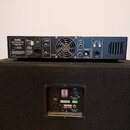 Fotografie zachycuje zadní stranu dvou zařízení. Horní modrý rackový zesilovač nese nápis Hartke, MODEL XL-200 a označení N382. Spodní černý reproduk…
