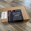 Kartonová krabice s produktem Antelope Audio EDGE NOTE Small Diaphragm Modeling Microphone. Na černé přebalové části je fotografie černého mikrofonu…