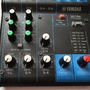 Černý míchací pult Yamaha MG06 MIXING CONSOLE. Na horní části jsou ovládací prvky pro kanály 1/L, 2/R a 3/4 - 5/6 včetně tlačítek PHANTOM +48V CH 1-2…