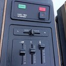 Detailní pohled na ovládací panel černého elektronického zařízení. V horní části je nápis NZC 160 STEREO, zelené tlačítko s nápisem STEREO a červené…