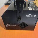 Černý generátor mlhy s kovovým šasi a montážním držákem. Na přední straně jsou bílé nápisy CHAUVET a HURRICANE HAZE 3D. Zařízení vykazuje mírné povrc…