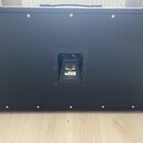 Zadní strana černého kytarového komba s texturovaným povrchem. Uprostřed je umístěn ovládací panel s nápisy "POWER", "212P" a "MADE IN CHINA". Povrch…
