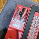 Červený efekt pedál s černým pedálem a nápisem WHAMMY. Na horním panelu je ovládací knoflík, přepínač SHALLOW DETUNE / DEEP a seznam intervalů pod na…