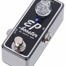 Kompaktní efekt pedál v kovovém stříbrném šasi s černým horním panelem. Na panelu je bílý nápis „EP booster“ a pod ním menší text „BY xotic usa“. Zař…