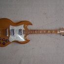 Elektrická kytara s dřevěným korpusem v hnědé barvě a bílým perleťovým pickguardem. Na hlavě nástroje je viditelné logo Epiphone. Kytara má dva humbu…
