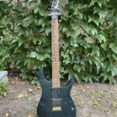 Elektrická kytara s tmavě modrým průsvitným lakem a vrstveným dřevem. Na hlavě hmatníku je bílý nápis Ibanez. Nástroj má dva humbuckery, jeden ovláda…