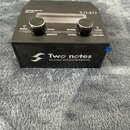 Černý efektový pedál s nápisem Two notes AUDIO ENGINEERING na přední straně. Horní panel obsahuje dva černé oválné ovladače a displej s nápisy OPUS,…