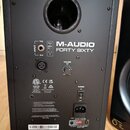 Zadní strana černého studiového monitoru s nápisy M-AUDIO a FORTY SIXTY. Jsou zde vidět vstupy INPUT (TRS a XLR), ovladač VOLUME, vypínač POWER a vst…
