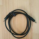 Černý audio kabel s konektory typu jack na obou koncích. Na kabelu je umístěn malý černý štítek s bílým nápisem VALUELINE 012555/1010. Povrch kabelu…