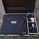 Otevřený hliníkový transportní kufr s černým vnitřním polstrováním. Uvnitř je černý krycí plát s bílým logem GLD a nápisem ALLEN & HEATH v pravém dol…