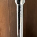 Detail chromovaného kovového stojanu s dvěma utahovacími šrouby. Na spodním prstenci je částečně viditelný nápis "KITA". Povrch vykazuje známky opotř…