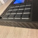 Černý MIDI kontrolér s mřížkou 16 štvrhových padů v šedé barvě. Na přední hraně je vyraženo logo AKAI PROFESSIONAL. Vlevo se nachází otočný knoflík s…